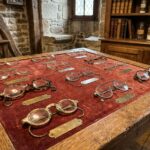 Collection de lunettes antiques du XVIIIe et XIXe siècle disposées sur du velours dans un atelier d'opticien breton historique