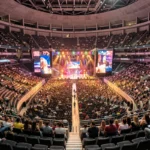 Vue panoramique intérieure de l'Accor Arena lors d'un concert avec gradins remplis et scène centrale illuminée